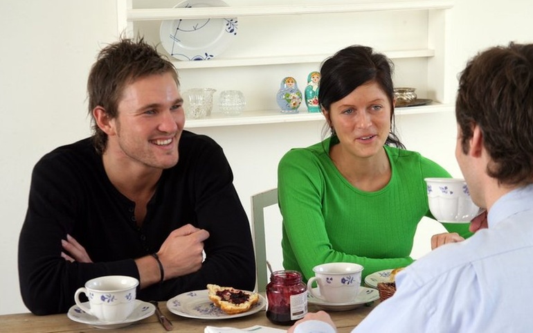 Tre mennesker spiser lunsj sammen