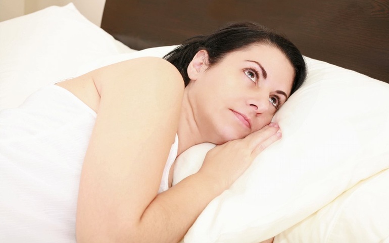 Kvinne våkner i seng